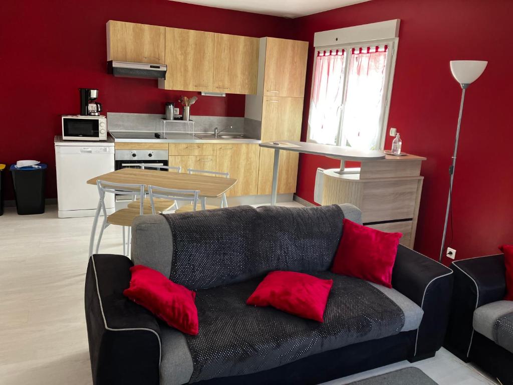 - un salon avec un canapé et des oreillers rouges dans l'établissement Location cures et vacances, à Jonzac