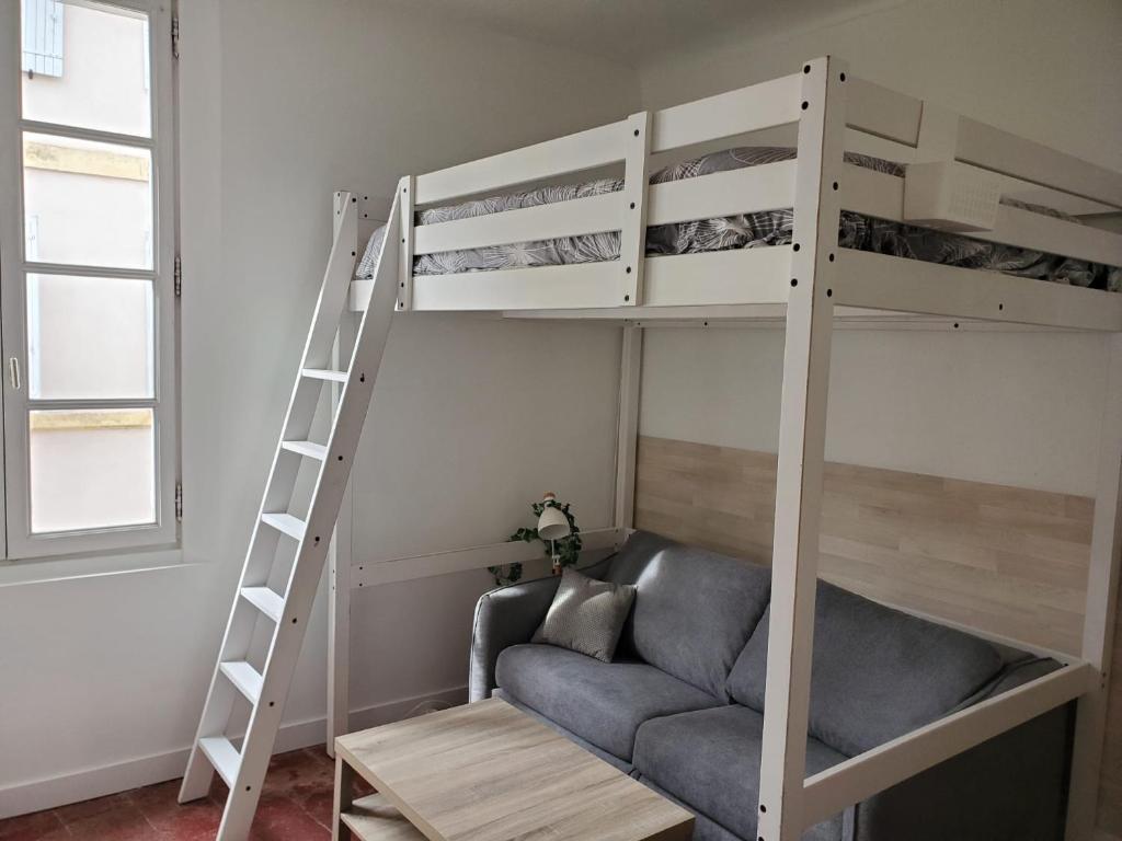 un salon avec un lit superposé et un canapé dans l'établissement Studio cosy centre historique, à Arles