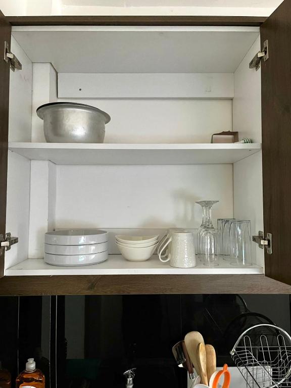 a kitchen shelf with bowls and dishes on it at Coaral Bells Tsavo in Kiambu