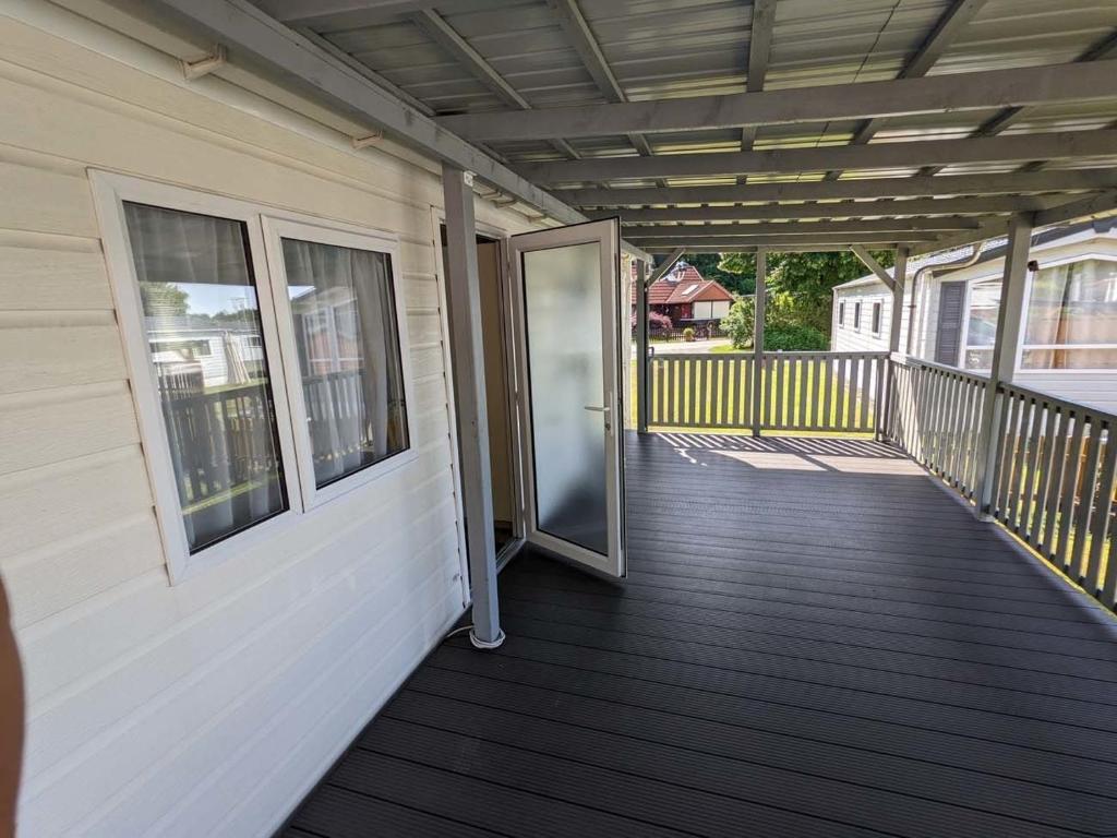 Balkón nebo terasa v ubytování Chalet Kegelrobbe mir riesiger überdachter Terrasse am Kransburger See 544