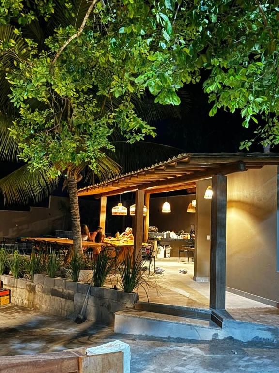 a restaurant with a table and a tree in front of it at Condomínio Ouro vilas in Arraial d'Ajuda
