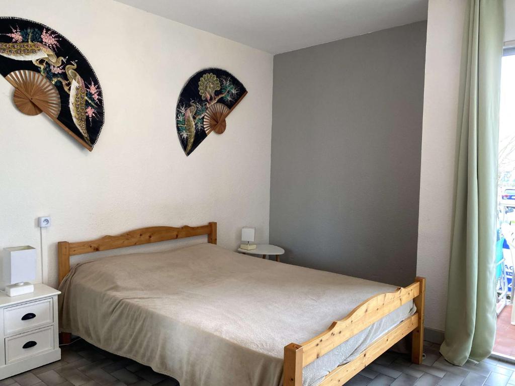 - une chambre avec un lit et deux assiettes murales dans l'établissement Studio Confortable avec Balcon et Wifi près du parc Charles de Gaulle à Balaruc-les-Bains - FR-1-553-37, à Balaruc-les-Bains