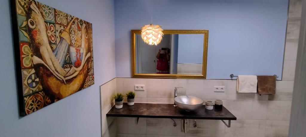 a bathroom with a sink and a large mirror at Ahornnest in Bingerbrück