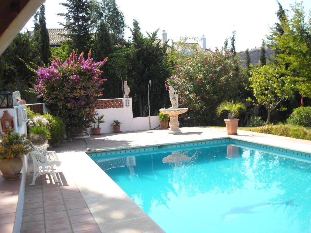 a swimming pool with a fountain in a yard at Finca La Ladera in Manilva