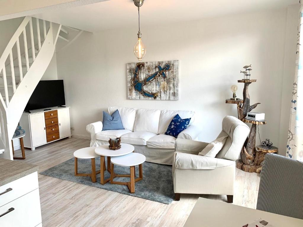 a living room with a white couch and a table at FeWo Seegras in Grödersby