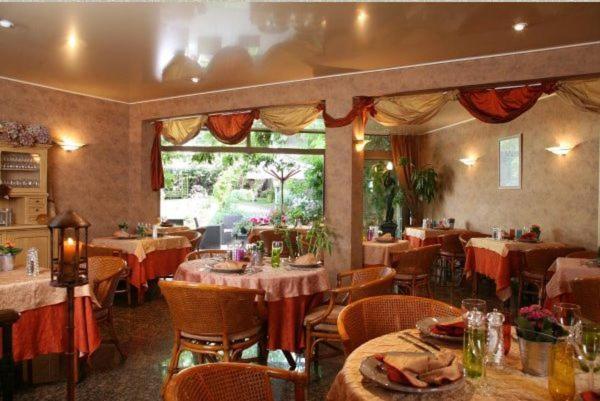 a restaurant with tables and chairs in a room at Hôtel Beatus in Cambrai