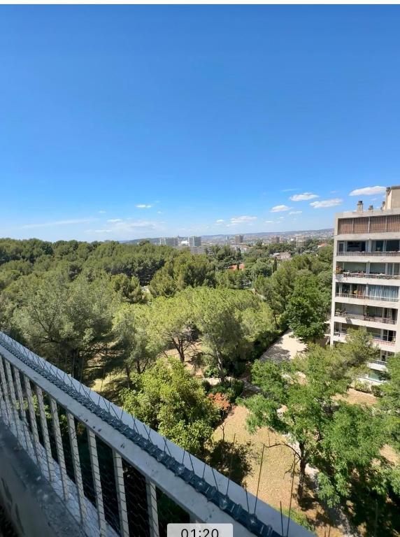 - un balcon avec vue sur un bâtiment arboré dans l'établissement Cocon Calanques Marseille, à Marseille