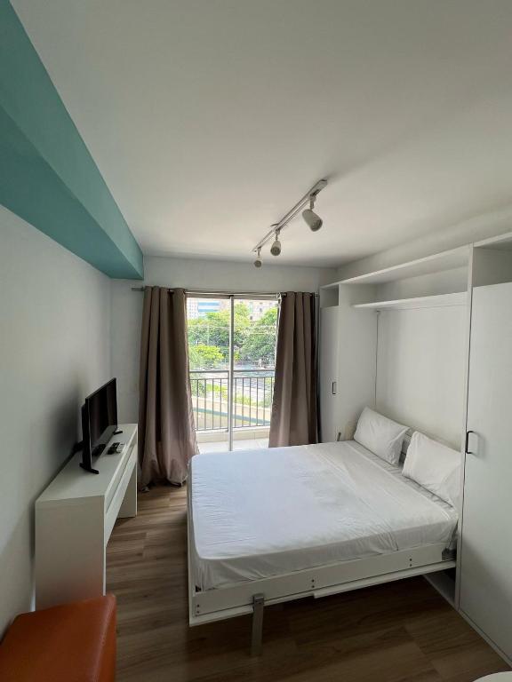 a bedroom with a white bed and a window at Flat Wise Confort in São Paulo