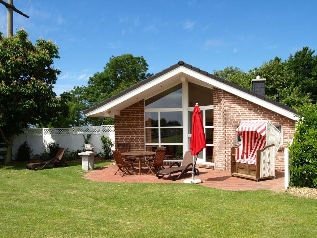 a small brick house with a table and chairs at Haus im Apfelgarten 1 in Fehmarn