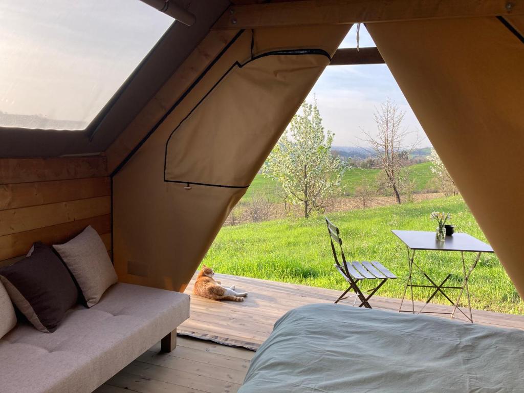 un letto e un divano in una tenda con vista di Agriturismo Glamping Pettirosso a Fratta Terme