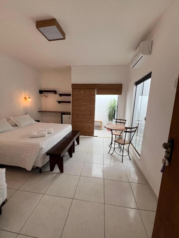 a bedroom with a bed and a table and chairs at La Fluorita Hospedaria in Morro do Chapéu