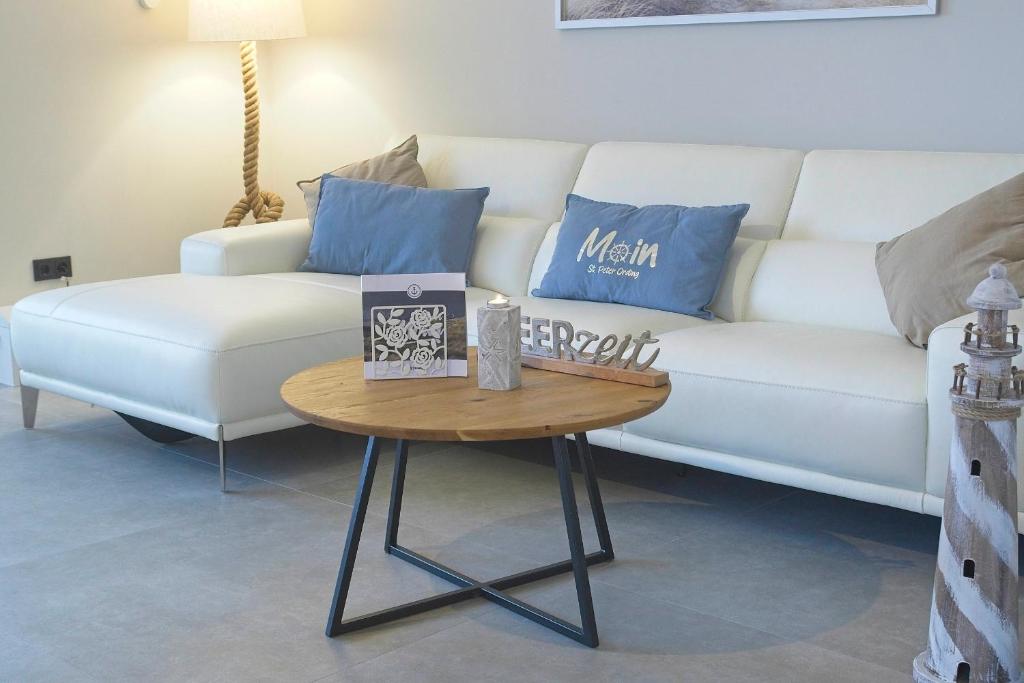 a living room with a white couch and a table at Strandperle in Sankt Peter-Ording