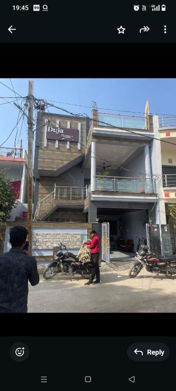a man pushing a motorcycle in front of a building at Duja Homes in Maihar