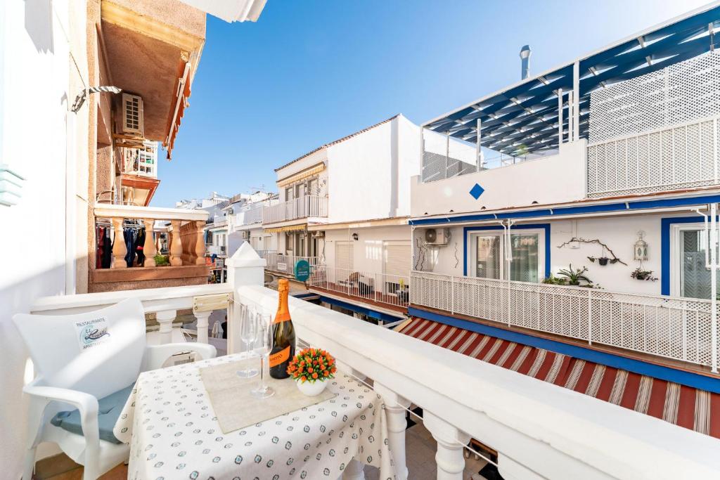 a balcony with a table and a bottle of wine at MalagaSuite El Levante Apartments in Torremolinos