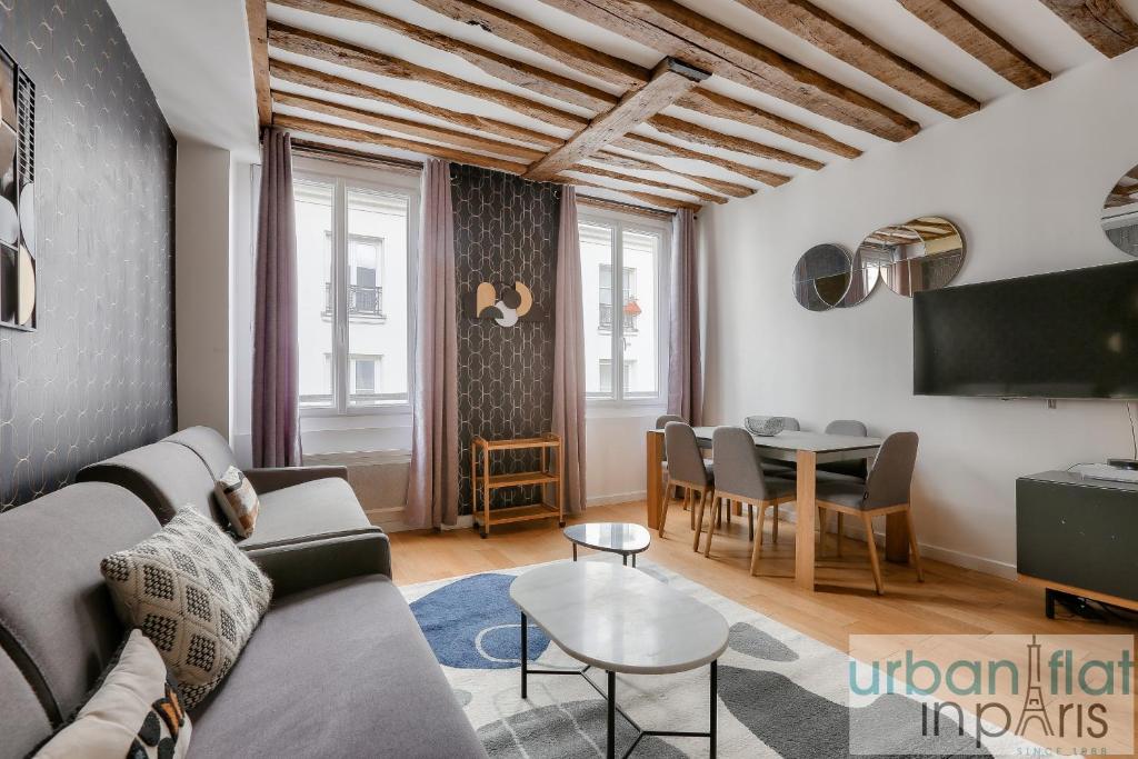 un salon avec un canapé et une table dans l'établissement Urban Flat 96 - 1 Bedroom Aboukir, à Paris
