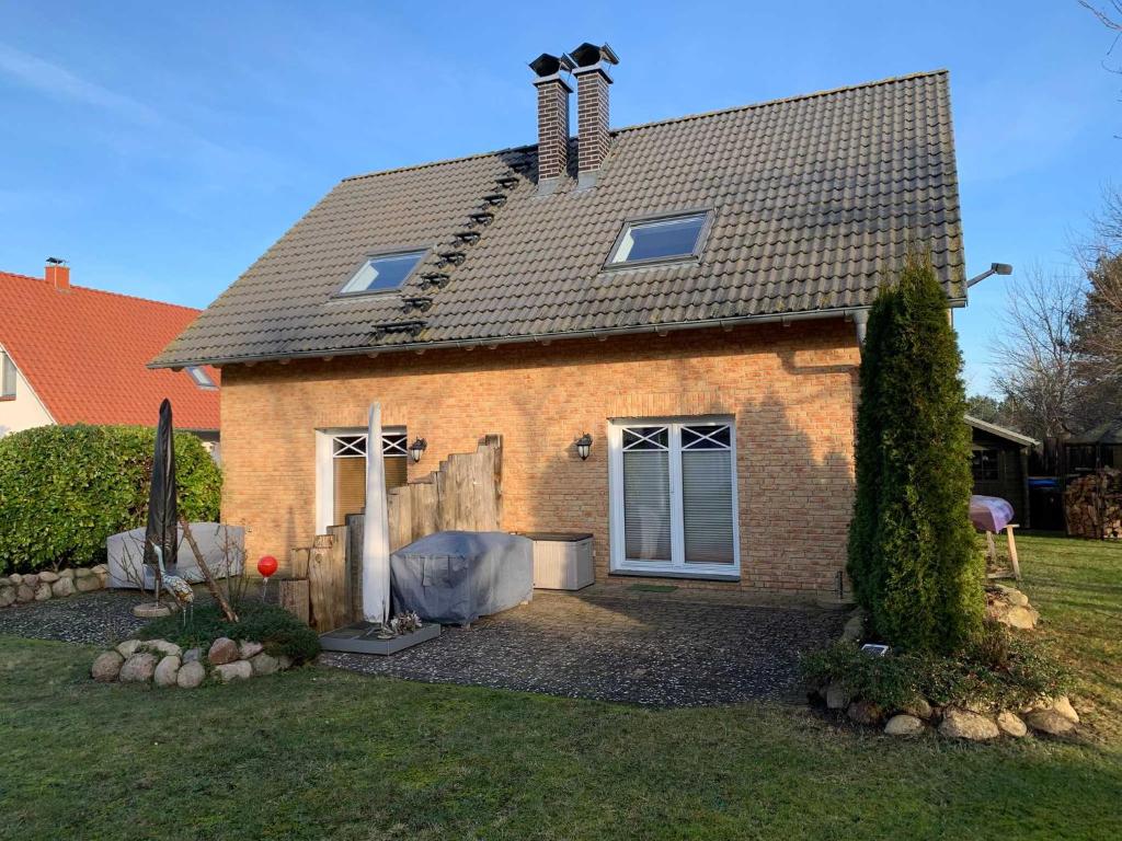 a brick house with a gambrel roof at Boddenblick 3B in Fuhlendorf