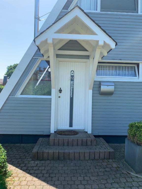 a house with a white door with a sign on it at Ferienhaus LiLeBe in Damp