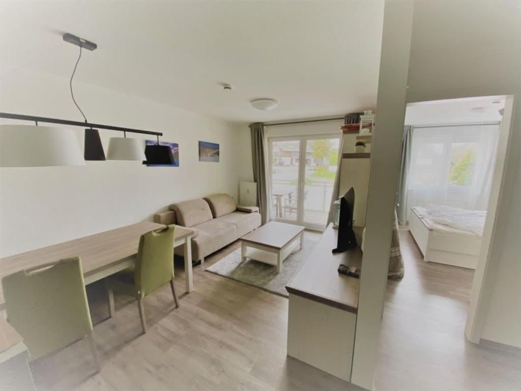 ein Wohnzimmer mit Tisch und Couch in der Unterkunft Blackforest Lounge direkt an der Skipiste, inkl Parkplatz und Skiraum in Rinken