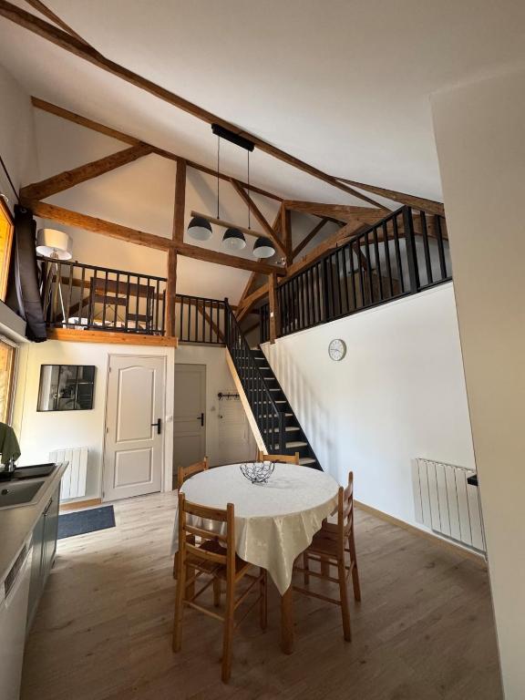 une cuisine et une salle à manger avec une table et un escalier dans l'établissement Charmant loft de montagne Tranquilité et confort, à Thollon-les-Mémises