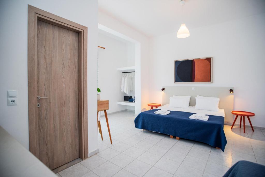 a bedroom with a bed and a wooden door at Seaside Suites in Kavos