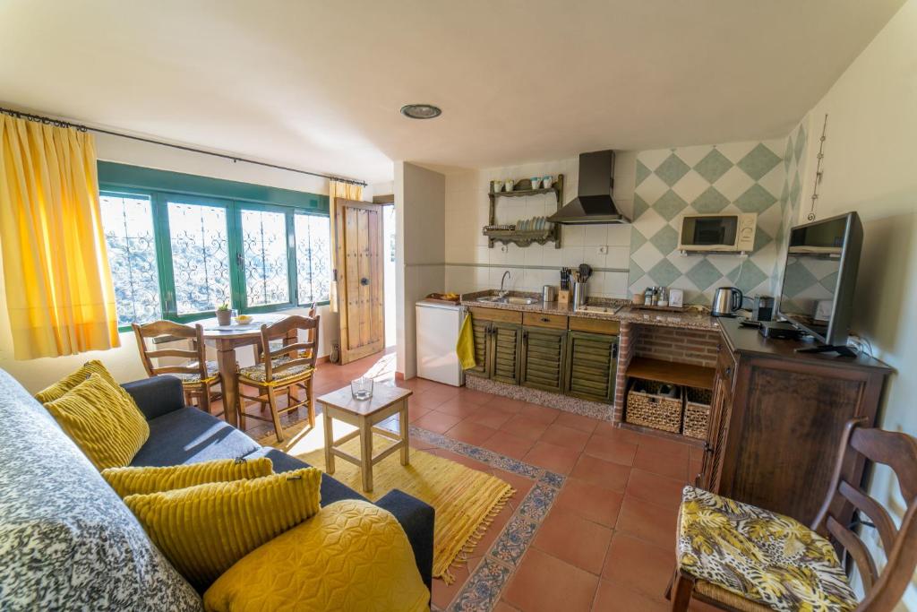 a living room with a couch and a kitchen at Casa El Limonero, Landhaus Mit Aussicht in Dúrcal