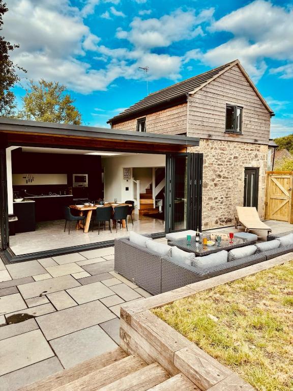 a house with a patio with a table at Knatchbull Cottage in Downhead