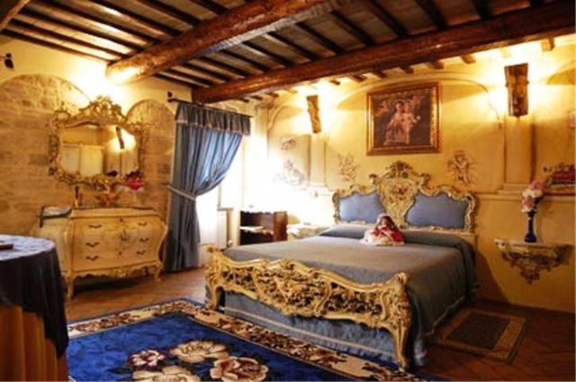 a bedroom with a king sized bed and a dresser at Il Paradiso del Re in Arcevia