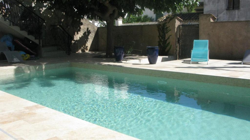 - une piscine avec une chaise bleue dans la cour dans l'établissement 13 Rue du Tour d'Enceinte, à Pomérols
