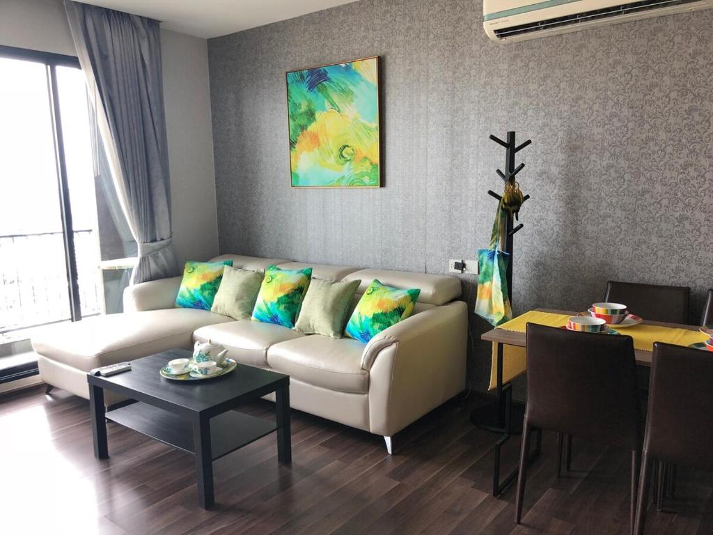 a living room with a couch and a table at BTS Bearing 23Fl 68sqm condo with open city view Shared rooftop and gym in Samut Prakan