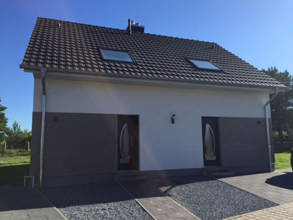 a house with two garage doors and a roof at "Segelboot" in Fuhlendorf