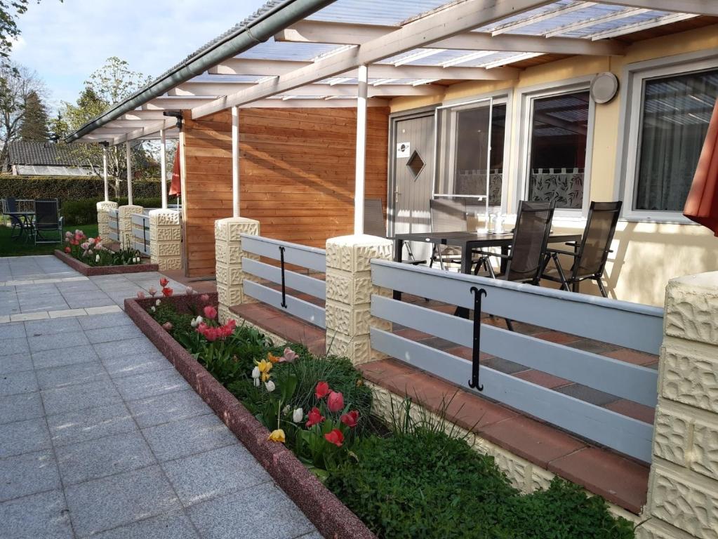 a porch of a house with a fence and flowers at Ferienhaus Saturn im Sternenpark in Lochow