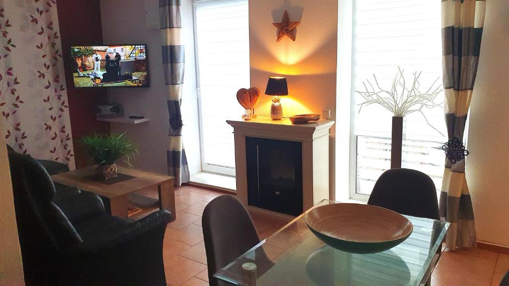 een woonkamer met een glazen tafel en een open haard bij Ferienwohnung Ostsee in Insel Poel