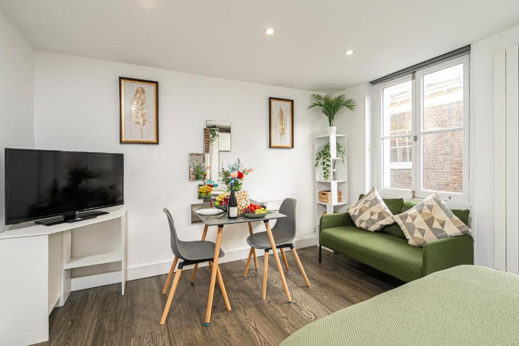 a living room with a green couch and a table at Green Park Studios in London