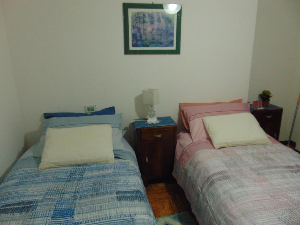 a bedroom with two beds and a picture on the wall at Podere Luma Camera Roseto - Mimosa in Gambassi Terme
