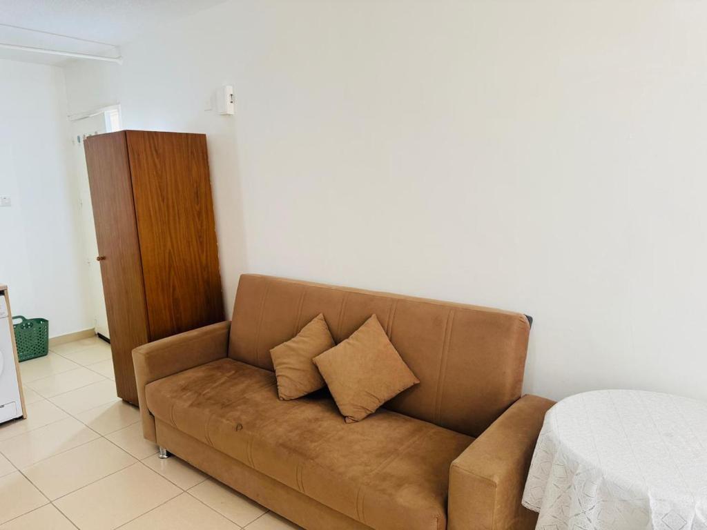 un canapé marron avec deux oreillers dans une pièce dans l'établissement Marielenas, à Larnaka