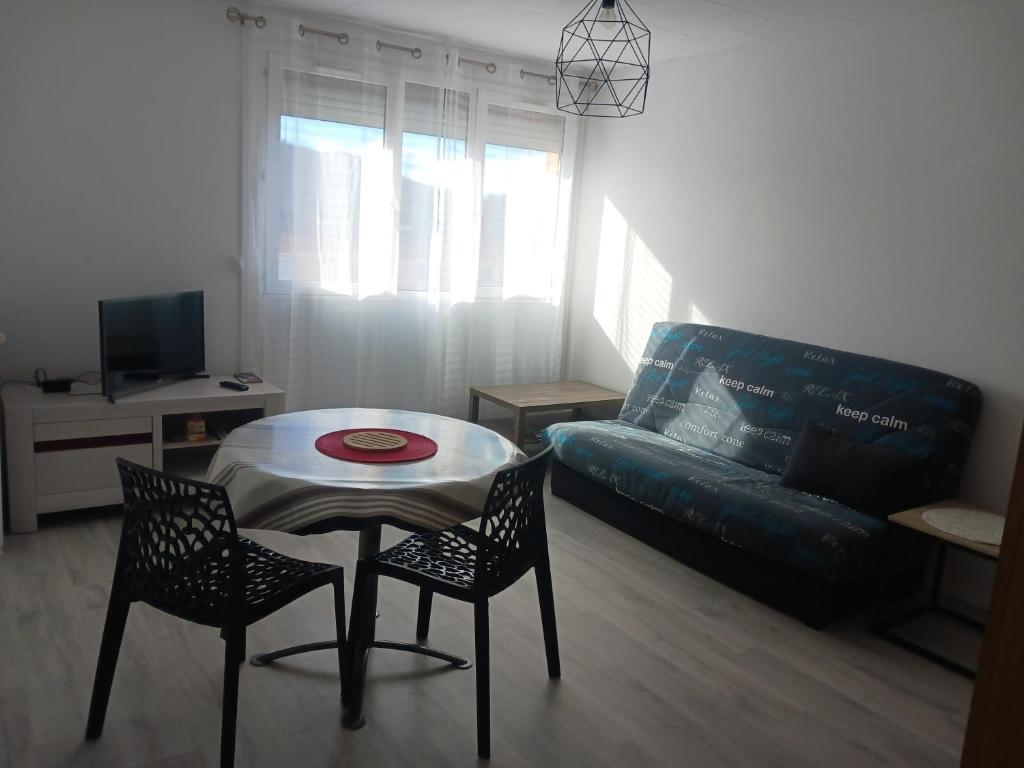 un salon avec une table, des chaises et un canapé dans l'établissement Superbe appartement avec parking privatif, à Cahors