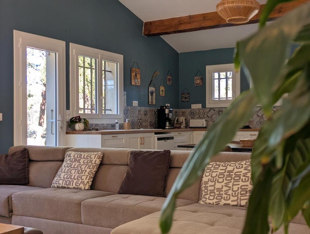 un salon avec un canapé et une cuisine dans l'établissement Villa Serenité avec Piscine au Coeur du Luberon, à La Tour-dʼAigues
