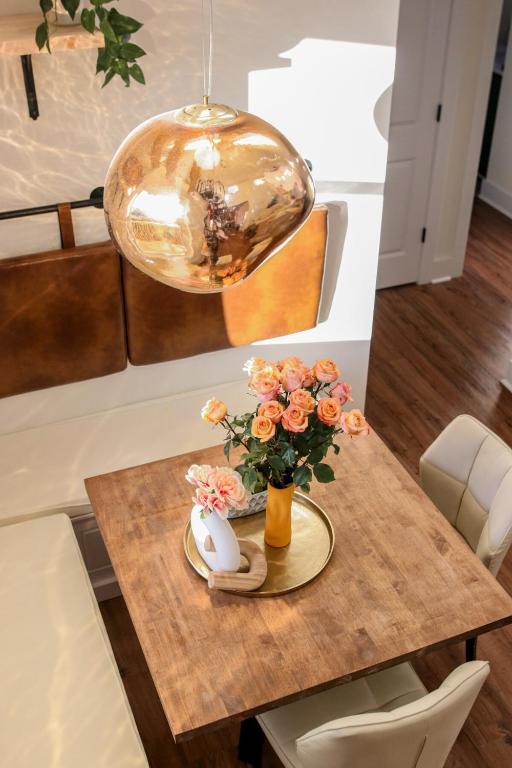 a table with a vase of flowers and a lamp at Loft vibes at the city Barn in Spartanburg