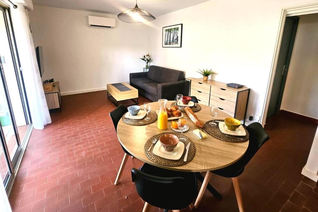un salon avec une table avec de la nourriture dessus dans l'établissement Cozy T2 with garden near the sea, à Saint-Mandrier-sur-Mer
