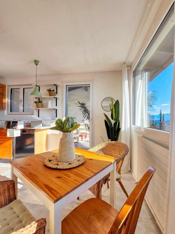 a dining room with a table and chairs and a window at Lakeview Hideaway - Brissago in Brissago