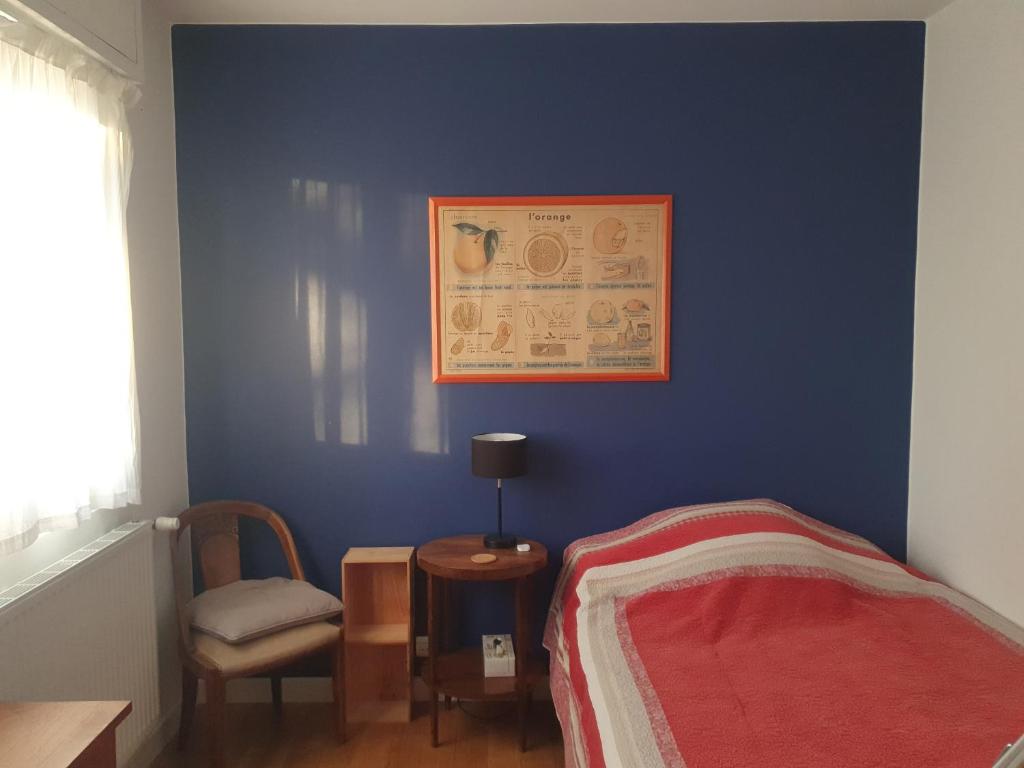 une chambre bleue avec un lit et une photo sur le mur dans l'établissement Chambre confortable dans un appartement lumineux, à Toulouse