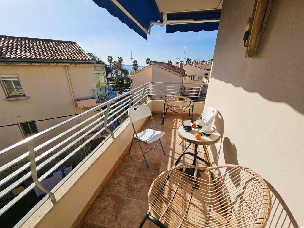 un balcon avec une table et des chaises sur un immeuble dans l'établissement Bel appartement avec balcon à 300m de plage, climatisation, internet..., à Six-Fours-les-Plages