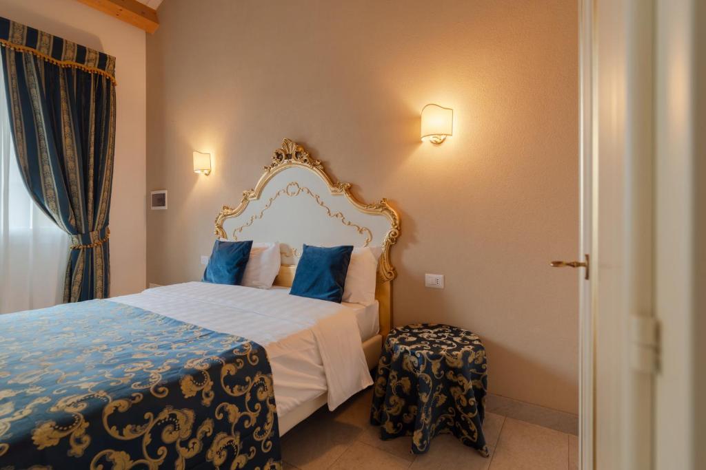 a bedroom with a bed with a blue and white bedspread at FloVe' Rooms Venice in Venice