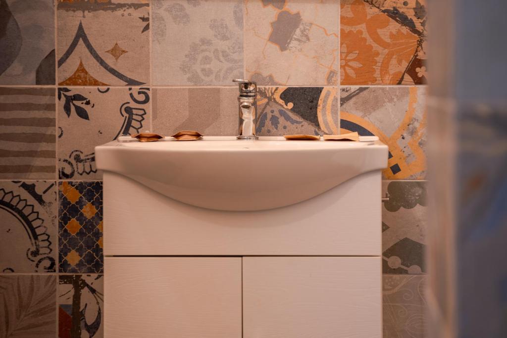 a white sink in a bathroom with tiles on the wall at FloVe' Rooms Venice in Venice