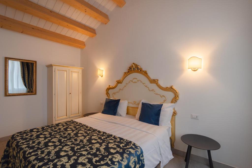 a bedroom with a large bed with blue pillows at FloVe' Rooms Venice in Venice