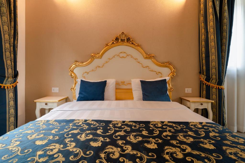 a bedroom with a king sized bed with blue pillows at FloVe' Rooms Venice in Venice