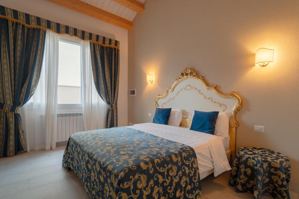 a bedroom with a bed with blue pillows and a window at FloVe' Rooms Venice in Venice