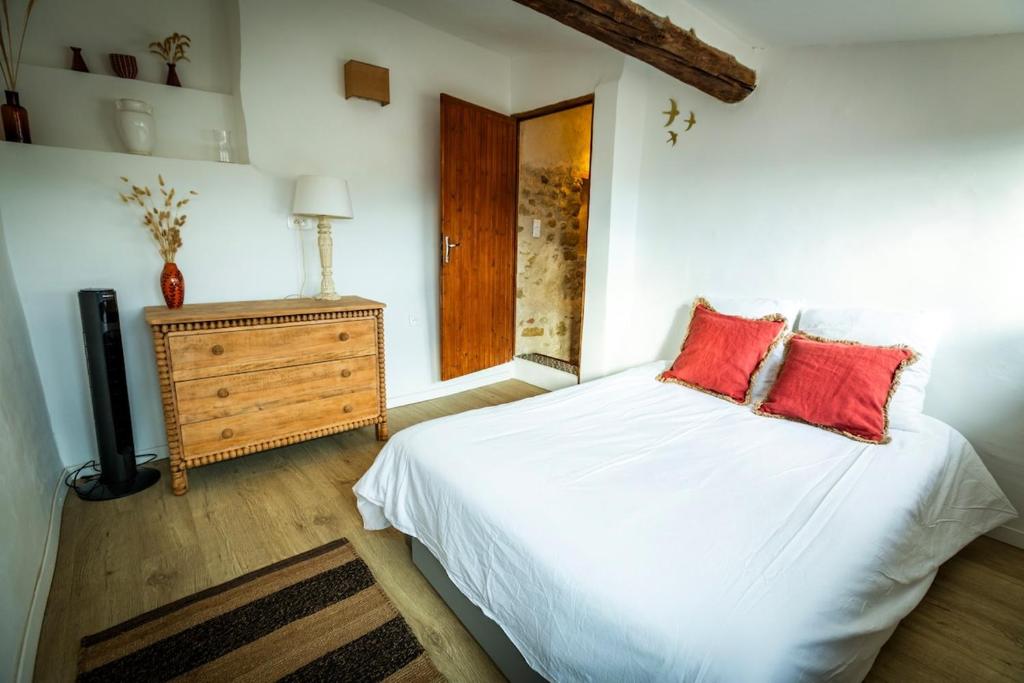 - une chambre avec un lit blanc et 2 oreillers rouges dans l'établissement Cadenet village house - 4 to 6 people, à Cadenet