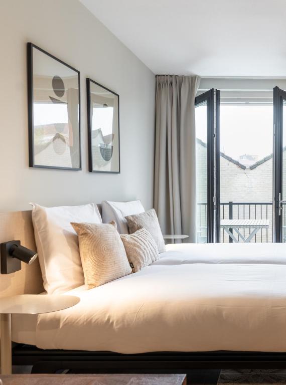 a bedroom with a large bed and a balcony at UtrechtCityApartments – Weerdsingel in Utrecht