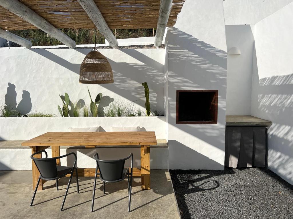un patio con tavolo e sedie in legno di Casa Sul - Casas de Seixe a Baiana